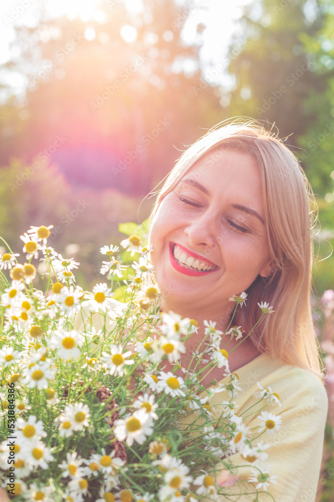 A girl in a yellow dress with a basket full of daisies in her hands A girl in a yellow dress with a basket full of daisies in her hands