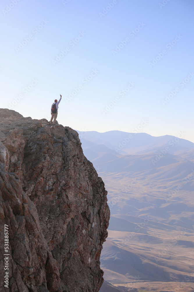 Man looking at the view on the edge of the cliff