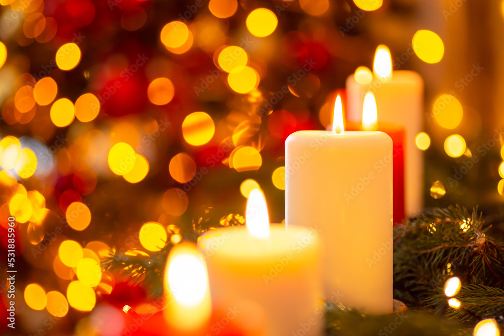 Close-up shot of bright candles in front of fir tree in lights. Celebrating Christmas concept Close-up shot of bright candles in front of fir tree in lights. Celebrating Christmas concept