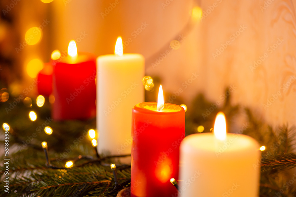 Line of burning red and white candles on fir tree branches. Christmas background of decorations Line of burning red and white candles on fir tree branches. Christmas background of decorations