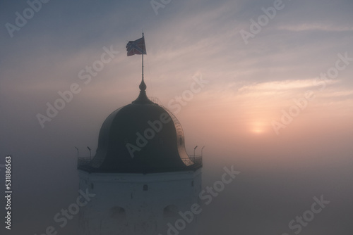 Aerial view of the tower of an ancient castle in Vyborg, Russia. Foggy morning photo