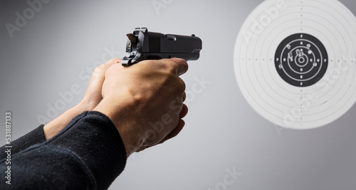 Hands with gun shooting target