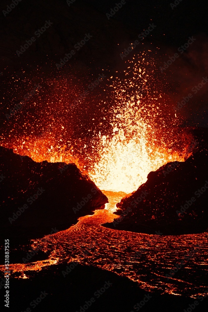 Vertical shot of lava splashing from a volcano at night in Iceland Stock Photo Adobe Stock