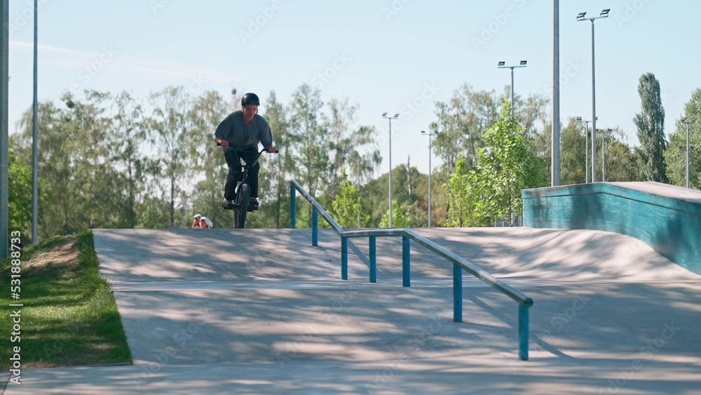 A professional cyclist rides and performs tricks on bmx. Beautiful stunts and bike jumps in the park on a concrete platform with obstacles. BMX. A professional cyclist rides and performs tricks on bmx. Beautiful stunts and bike jumps in the park on a concrete platform with obstacles. BMX.