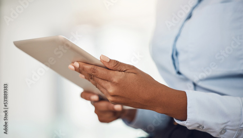 Hands of business woman working on a tablet analyzing annual company data or information for marketing campaign. Professional black girl with digital mobile tech for research on consumer sales trends