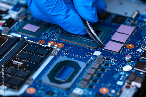 Technician repairing inside of thermal pad for Integrated Circuit. the concept of data, hardware repairing, upgrade technology. photo