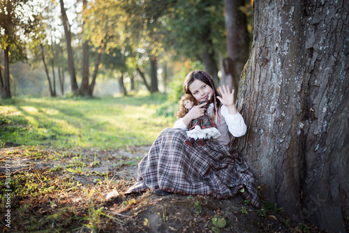 Dziewczynka bawi się w parku swoją lalką
