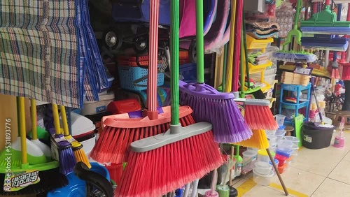 Video of an open air market in Lima selling brooms and mops and other cleaning supplies. Camera tilts up and many different colored brooms can be seen hanging. Recorded in Lima, Peru in 4k quality. photo