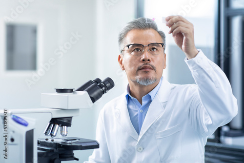 Scientist looking at a microscope slide photo