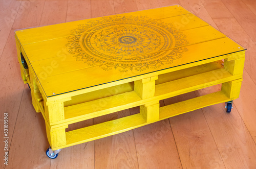 Beautiful wooden yellow table surface with mandala hand drawings