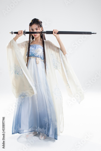 Young woman in ancient costume holding a sword photo