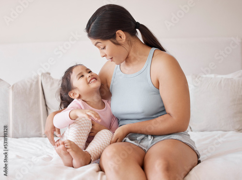 Happy mother in bedroom has fun with child, bonding together in bed at home while they smile and hug. Family, love and happiness when you have a kid are good for a healthy childhood life growing up