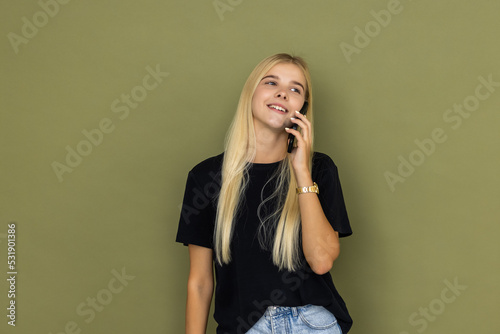 Young happy woman talk speak on mobile cell phone conducting pleasant conversation isolated on khaki background. People lifestyle concept