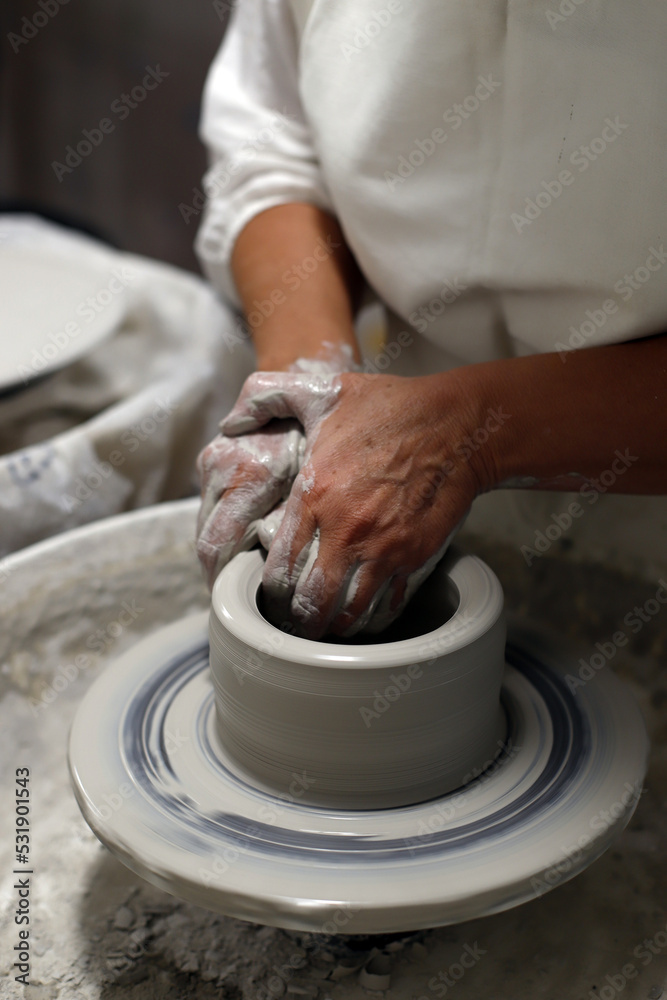 manos trabajando alfarería de cerámica artesanal en el torno
