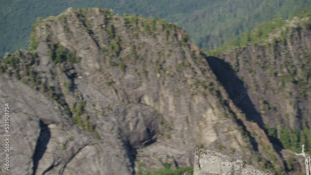 Photographer takes shaka selfie with phone on mountain ridge with epic view, Tim Durkan wide tracking helicopter counterclockwise orbit SLOW MOTION Photographer takes shaka selfie with phone on mountain ridge with epic view, Tim Durkan wide tracking helicopter counterclockwise orbit SLOW MOTION