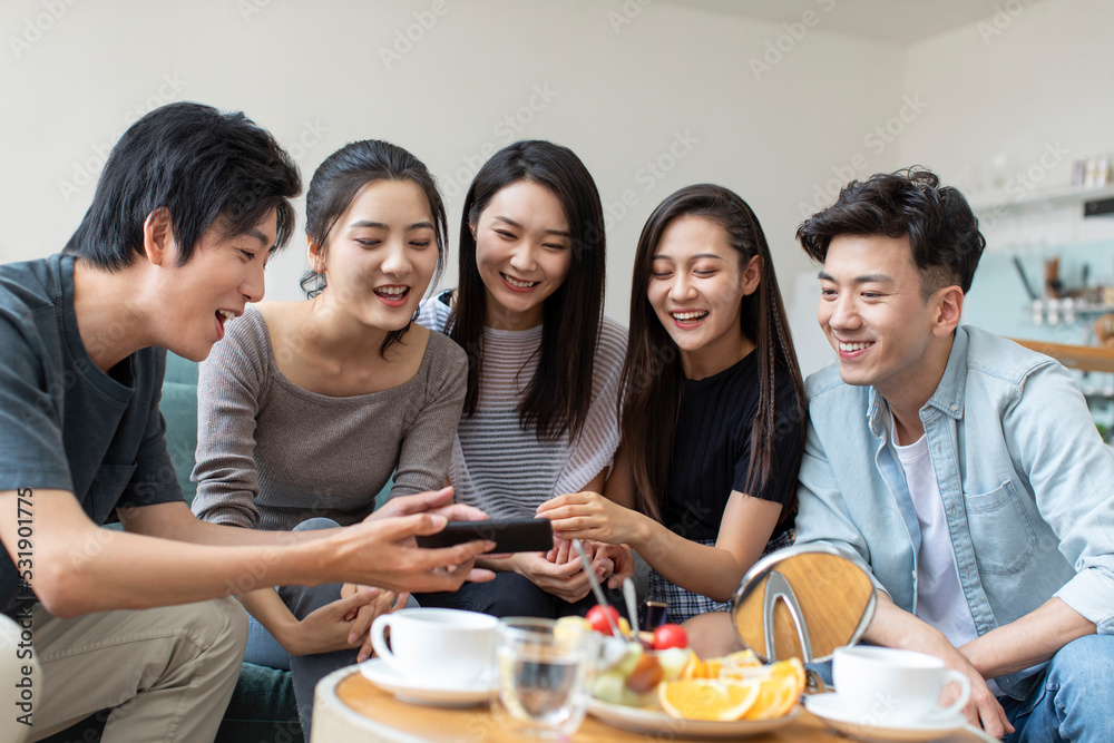 Young friends using smart phones on sofa Young friends using smart phones on sofa