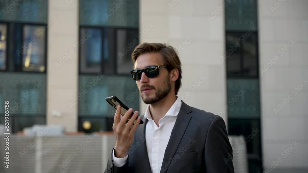 Handsome Startup Businessman using mobile Phone. Young man texting Messages, talking on his Smartphone while walking Handsome Startup Businessman using mobile Phone. Young man texting Messages, talking on his Smartphone while walking