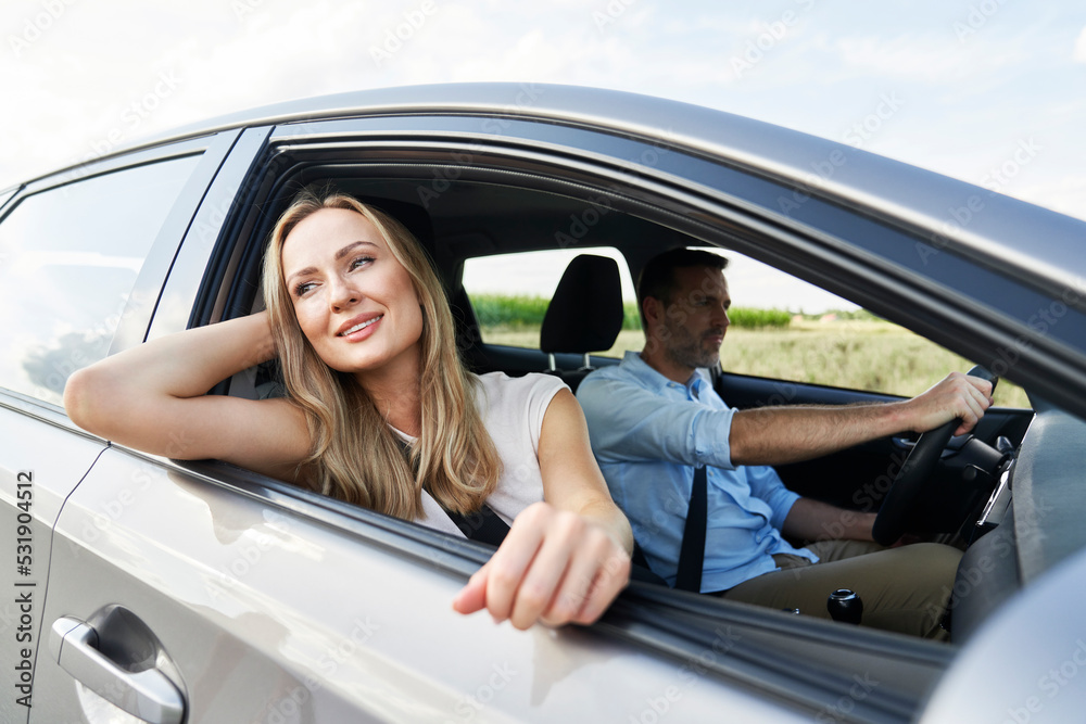 Blonde woman driving a car with husband