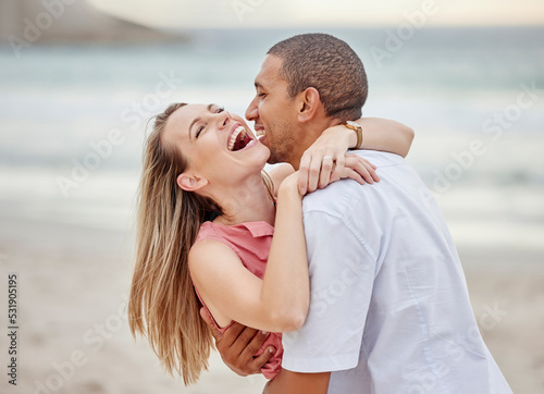 Beach, hug and happy couple celebrate love, dating and marriage at sea, ocean water or luxury vacation travel. Man and woman smile on date in celebration for surprise and joy sunset summer holiday