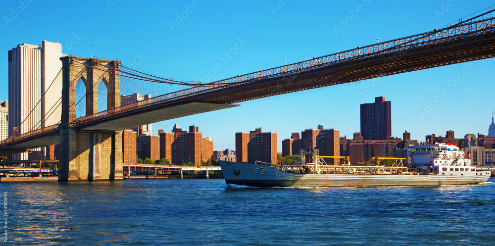 Cargo ship and Brooklyn bridge in NYC