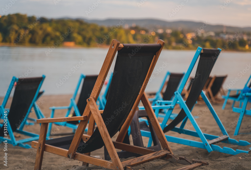 Empty wooden chairs deck chairs by the river at the beach Empty wooden chairs deck chairs by the river at the beach