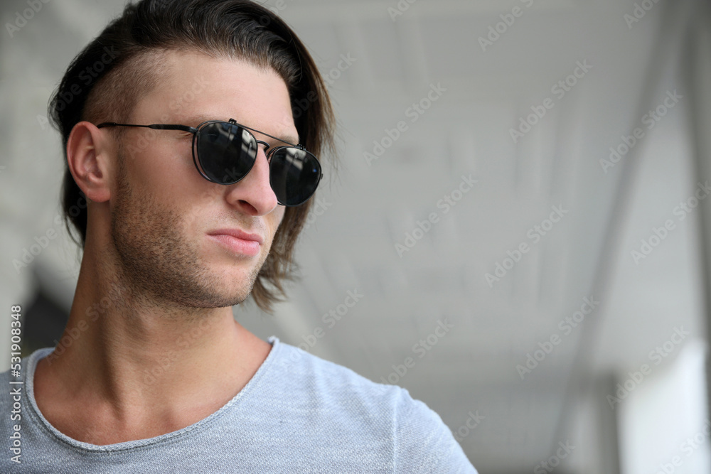 Portrait of handsome young man in stylish sunglasses indoors. Space for text Portrait of handsome young man in stylish sunglasses indoors. Space for text