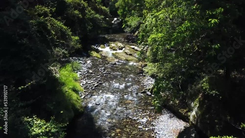 The Drone flies above a mountain stream and deeper into the rainforest. photo