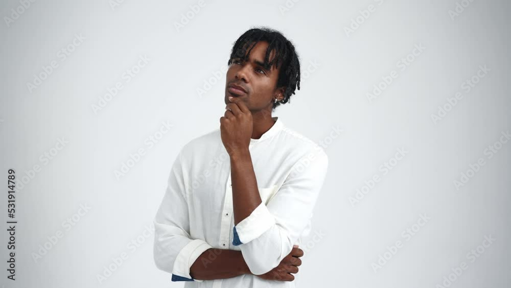 Pensive African man with dreadlocks thinking in the white studio Pensive African man with dreadlocks thinking in the white studio