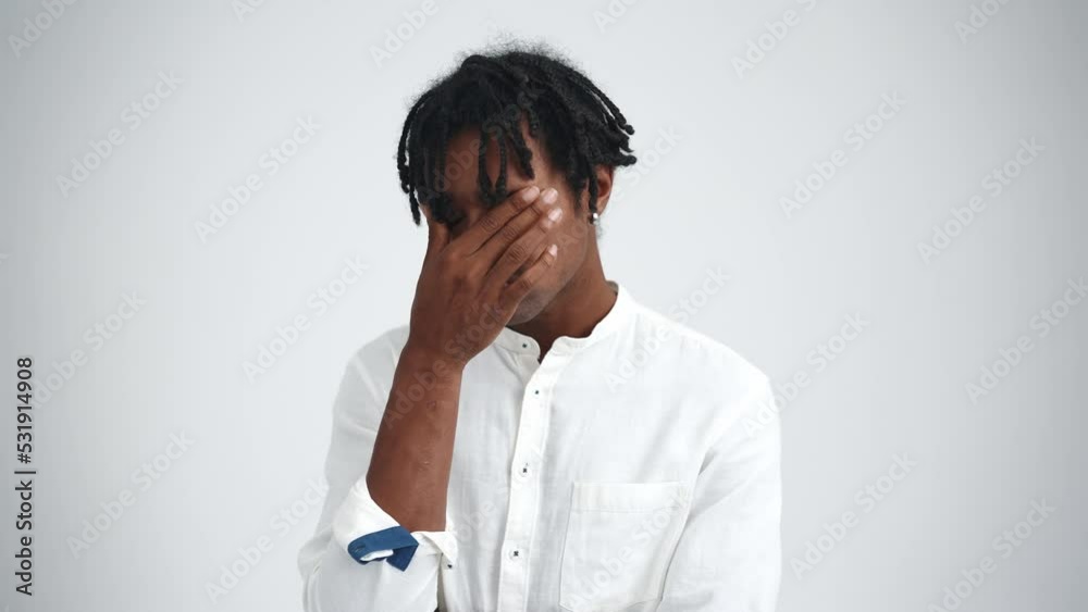 Bored African man with dreadlocks thinking about something in the white studio Bored African man with dreadlocks thinking about something in the white studio