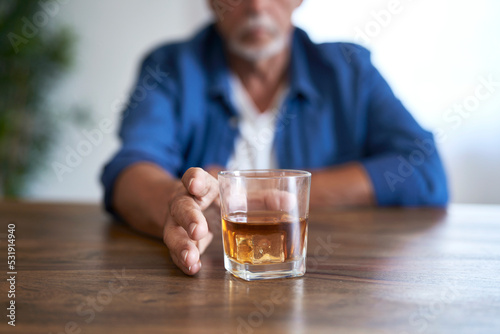 Senior caucasian man taking glass of wishy at home