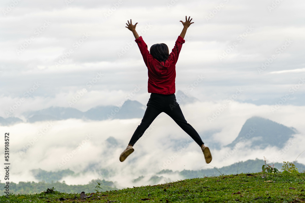successful woman hiker jumping on a mountain top successful woman hiker jumping on a mountain top