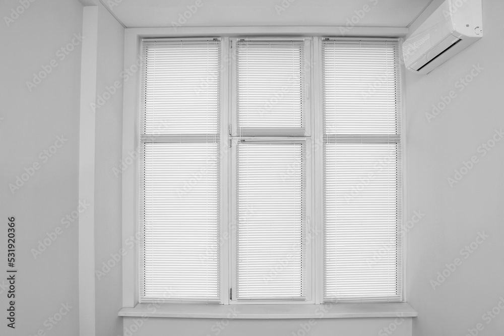Fototapeta premium Stylish window with horizontal blinds in room