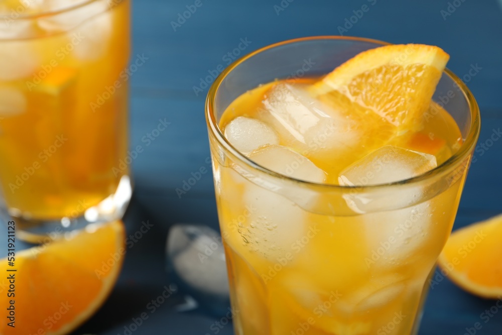 Fototapeta premium Delicious orange soda water on blue background, closeup