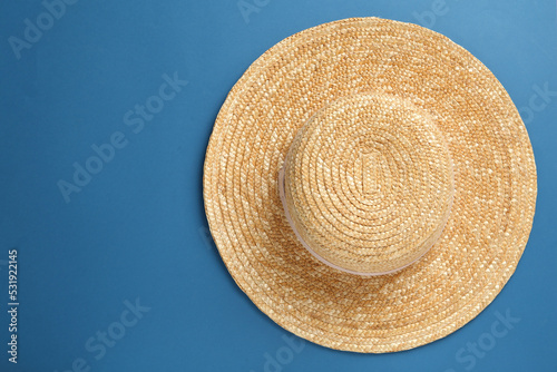 Stylish straw hat on blue background, top view. Space for text