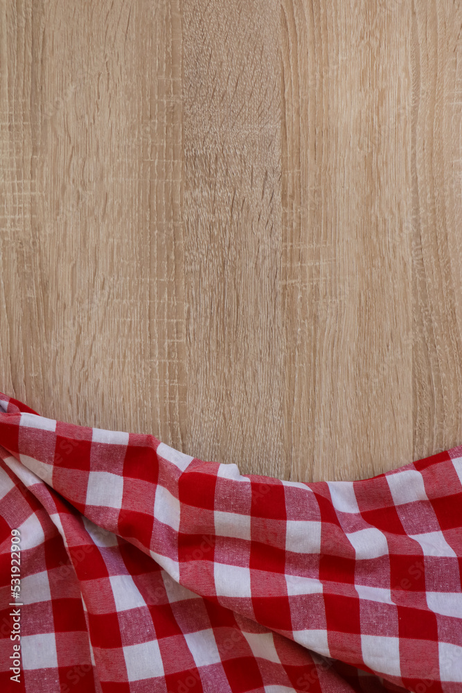 Checkered picnic cloth on wooden table, top view. Space for text Checkered picnic cloth on wooden table, top view. Space for text
