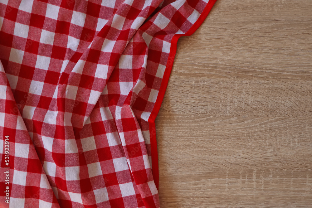 Checkered picnic cloth on wooden table, top view. Space for text Checkered picnic cloth on wooden table, top view. Space for text