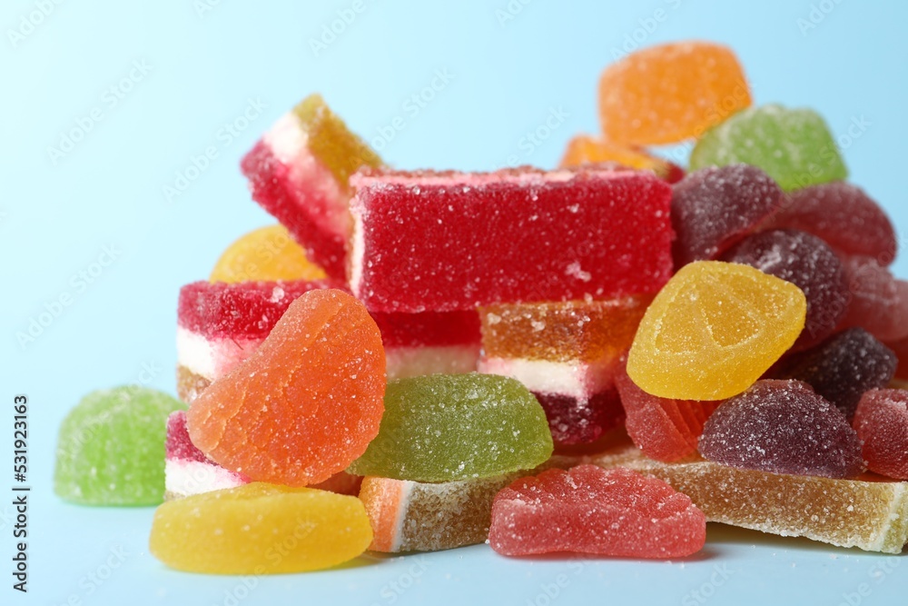 Pile of delicious bright jelly candies on light blue background, closeup Pile of delicious bright jelly candies on light blue background, closeup