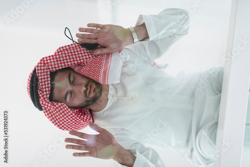 Muslim man doing sujud or sajdah on the glass floor photo