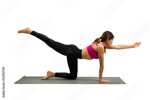 Fit hispanic woman practicing a tiger yoga pose while working out