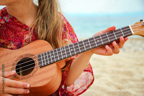 happy child playing guitar by the sea greece on nature background