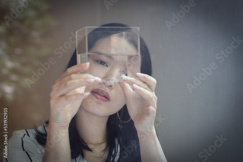 Curious female designer looking at cube with water photo