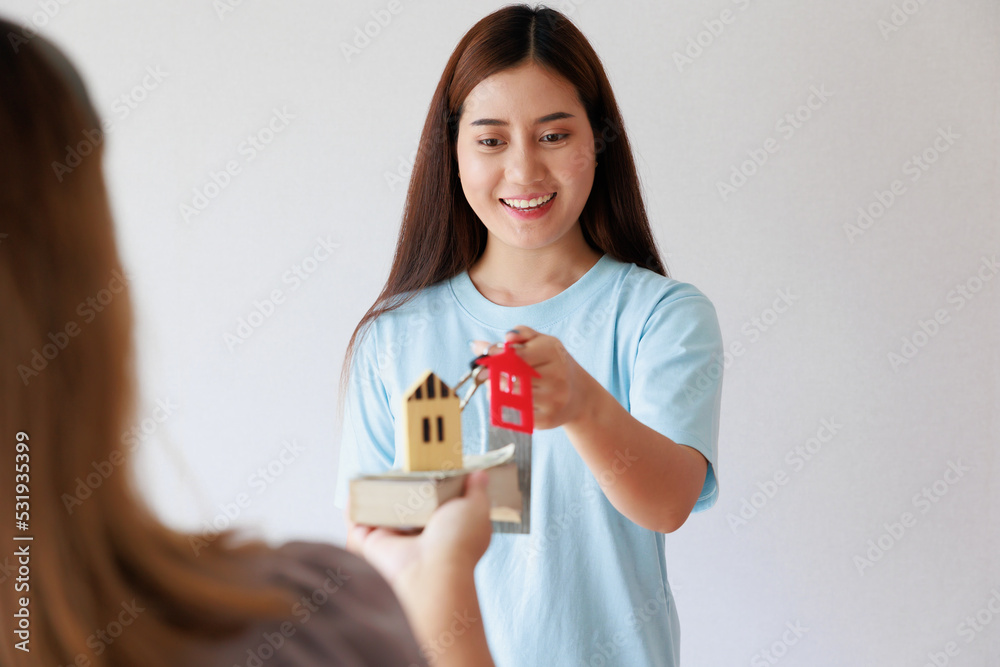 Smiling asian woman receives hand over keys for new house Smiling asian woman receives hand over keys for new house