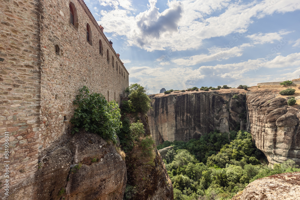This panoramic angle of scenic Meteora landscape with rock formations and Saint Stephen Nunnery on the cliff was taken from the only bridge connecting the monastery with the rest of the world, Greece