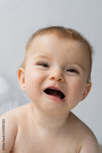 Portrait of happy baby girl with opened mouth looking away at home.