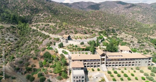 Aerial drone footage of Holy monastery of Panagia Amirous in Apsiou, Limassol, Cyprus. Fly over view of the religious stone church, ceramic roof tiles and surrounding mountain landscape from above
