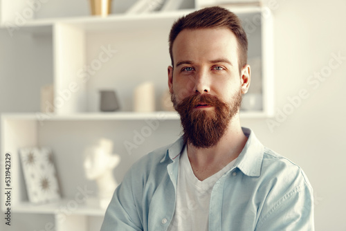 Bearded smiling handsome young man portrait alone at home