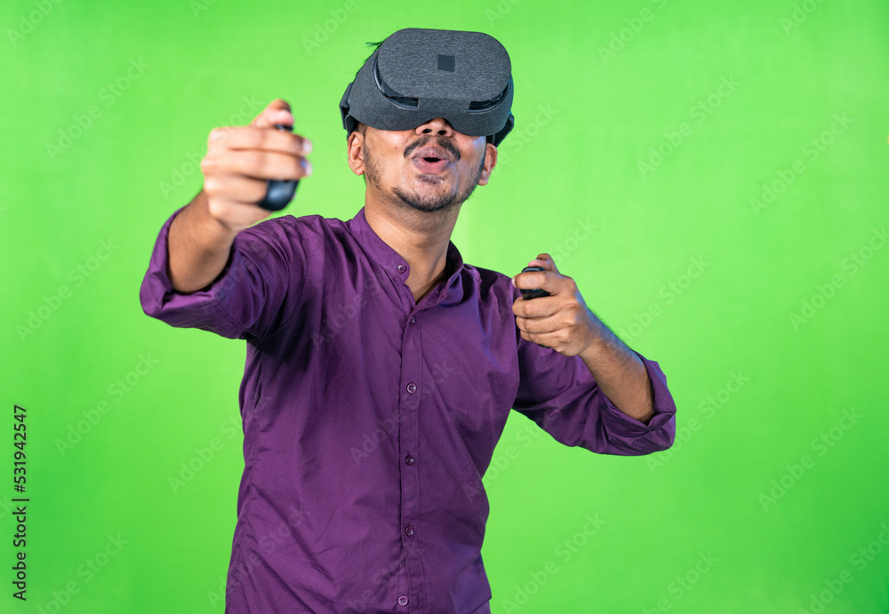 Excited young man with vr or virtual reality headset playing video game on metaverse using joystick on green screen background - concept of technology, entertainment and imagination Excited young man with vr or virtual reality headset playing video game on metaverse using joystick on green screen background - concept of technology, entertainment and imagination