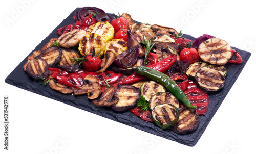 Grilled vegetables mix on a stone serving board - zucchini eggplant onions corn mushroom tomato