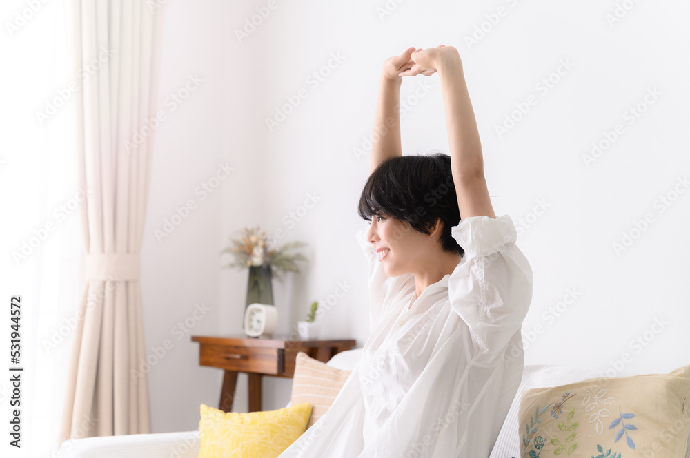 Woman stretching comfortably in her room, profile Woman stretching comfortably in her room, profile