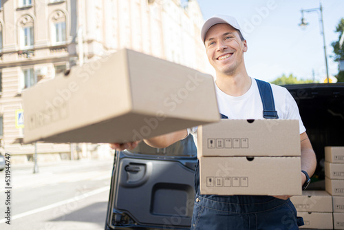 Courier delivery a male driver delivers orders in boxes to the house. Uniform and cap for an employee. © muse studio
